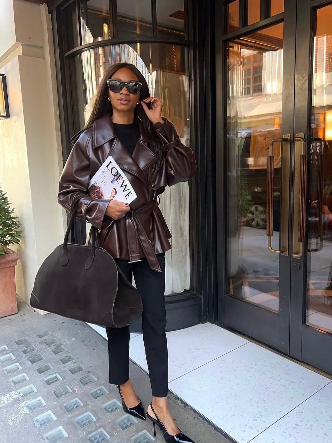 Influencer Lorna Symphony wearing a leather brown jacket and holding a brown bag