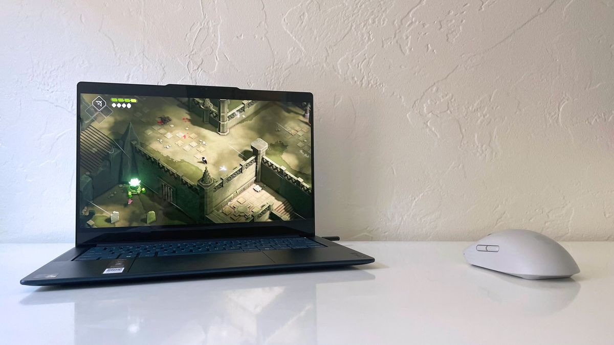 The Lenovo Yoga Slim 7x running Death's Door on a white desk next to a gray gaming mouse