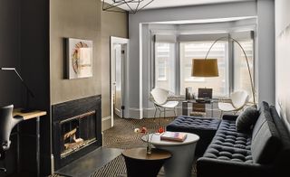 Living room with black sofa, 2 white chairs and lamp