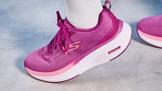 the skechers go run elevate 2.0 running shoes in the women's style, in fuchsia pink, photographed against a blue background