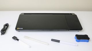 A desktop whiteboard on a desk with all of the included accessories
