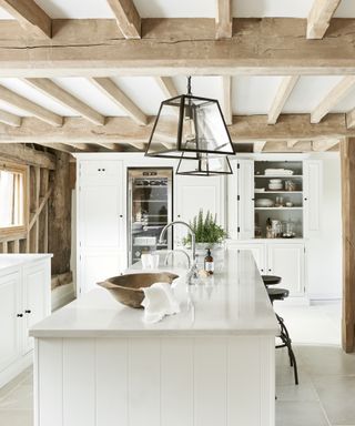 White glossy kitchen island with large glass pendant lights