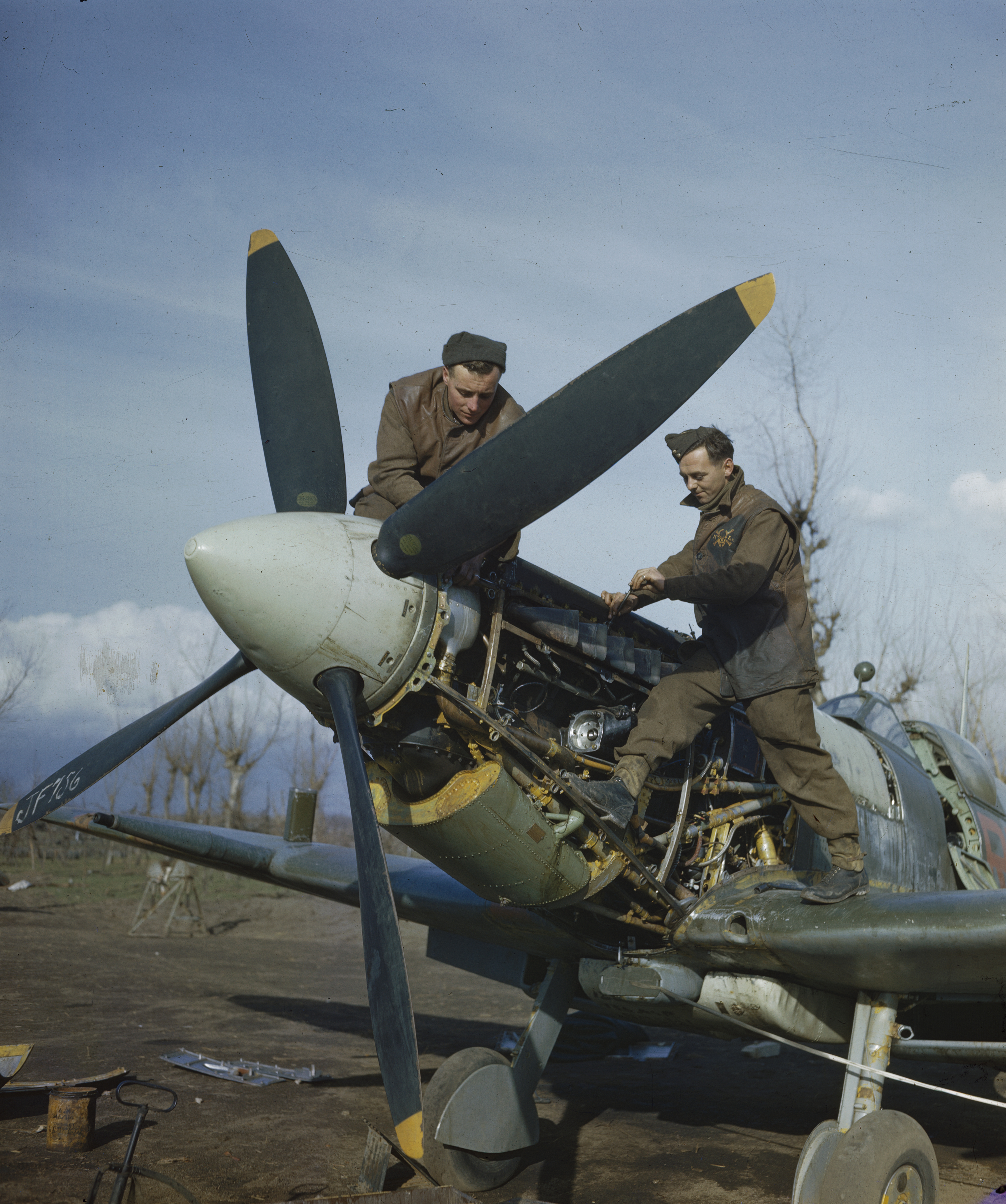 Aircraftman Jim Birkett and Leading Aircraftman Wally Passmore perform maintenance on the Merlin engine of a Supermarine Spitfire of No 241 Squadron in Southern Italy, 1944