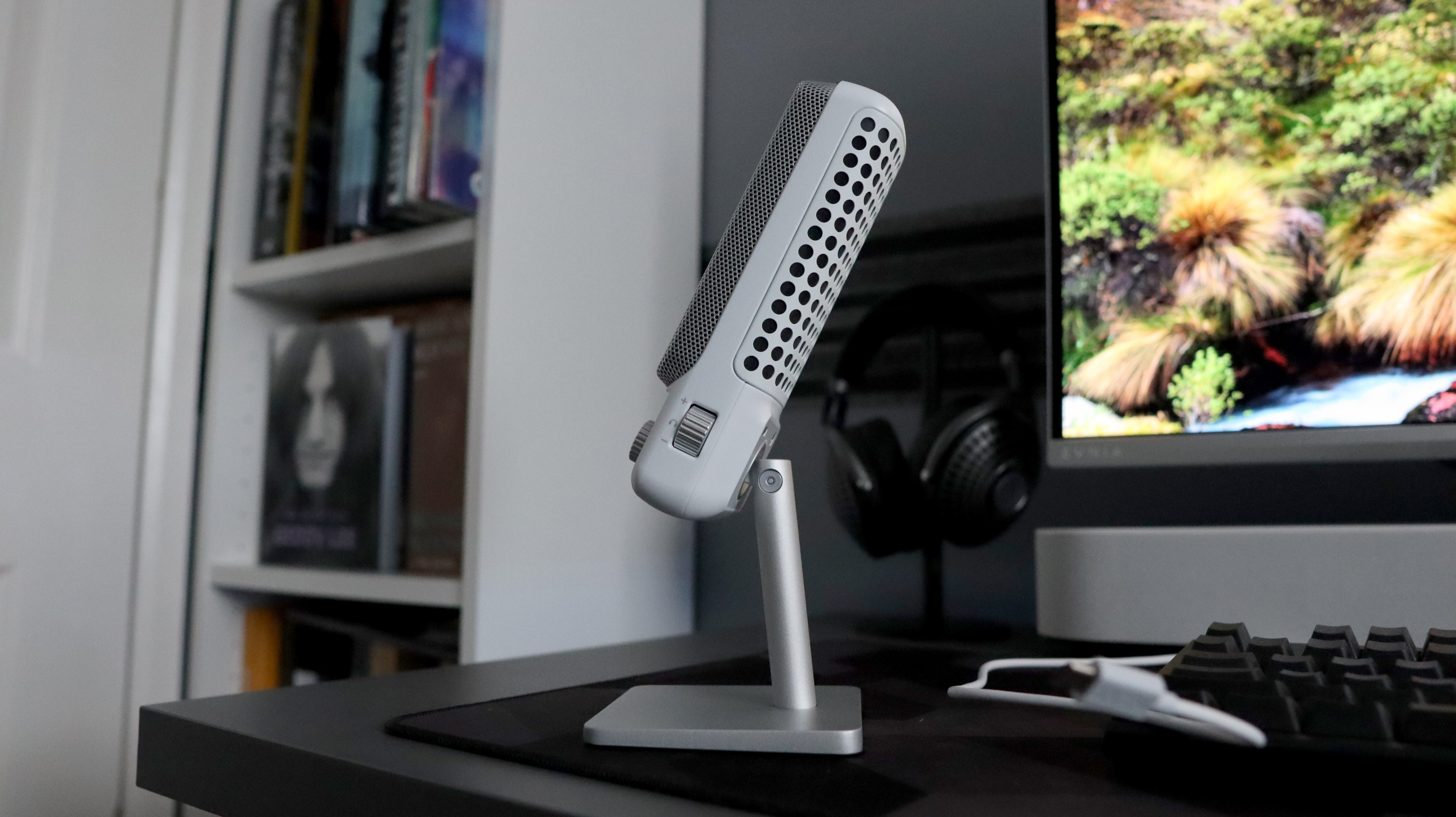 An NZXT Capsule Elite microphone set up on a desk with lighting enabled.