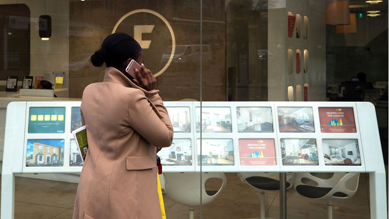 Woman looking in an estate agent&amp;#039;s window