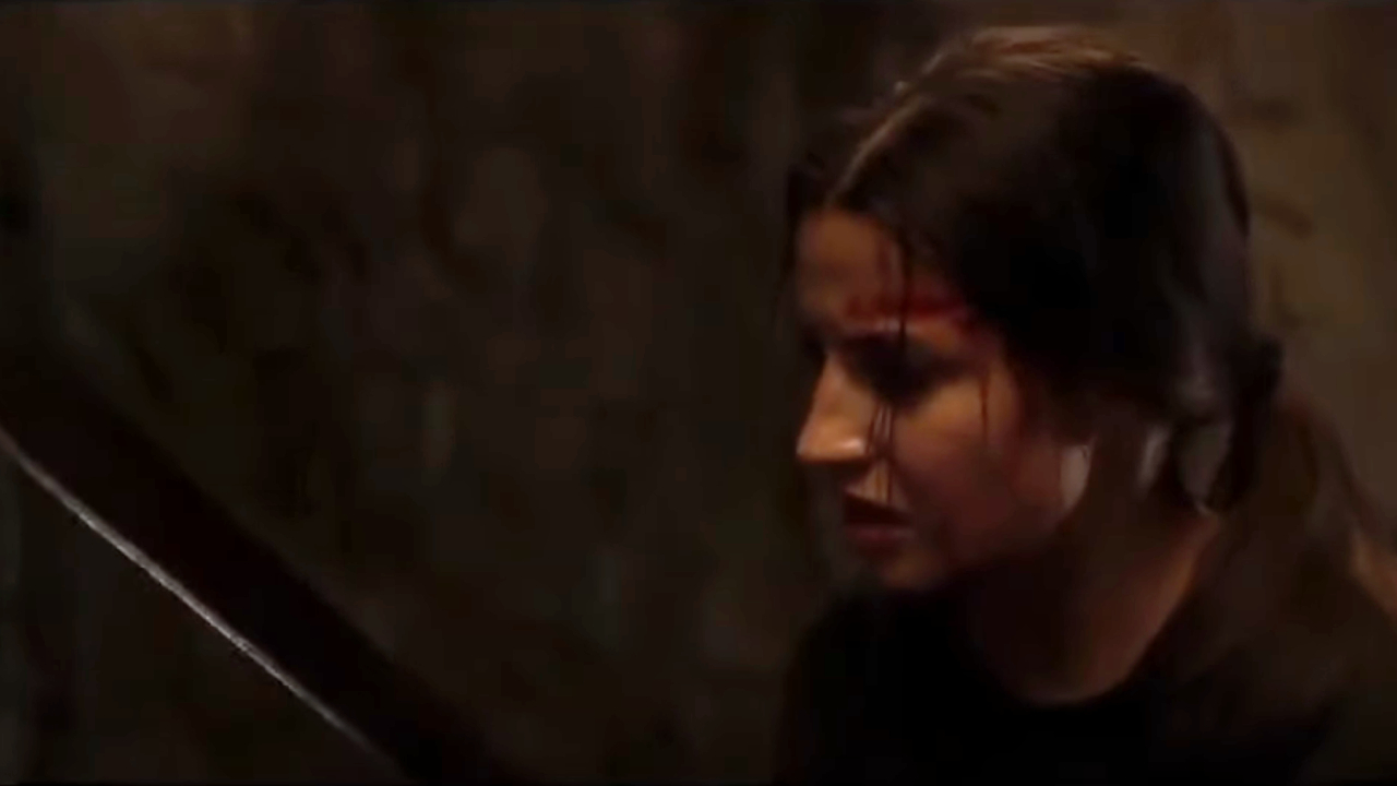 Julia Wieniawa holding a machete nervously in Nobody Sleeps In The Woods Tonight