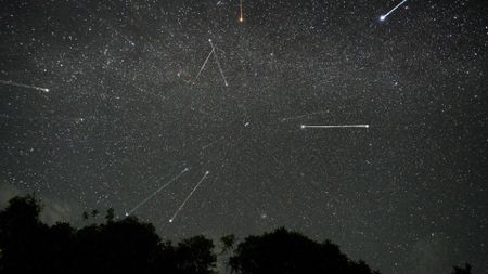 streaks of light crisscross among the stars in the night sky