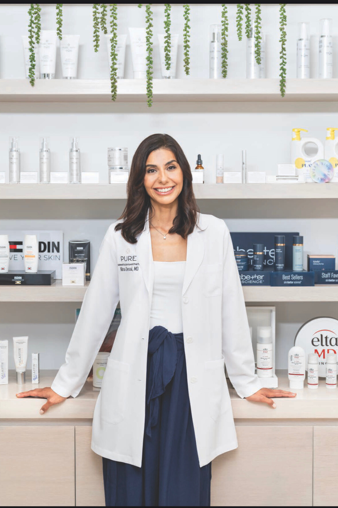 a white woman with short brown hair in a white lab coat and blue pants