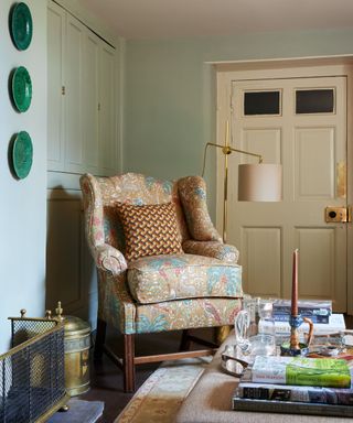 traditional living room with light blue-gray walls, upholstered armchair and eclectic decor