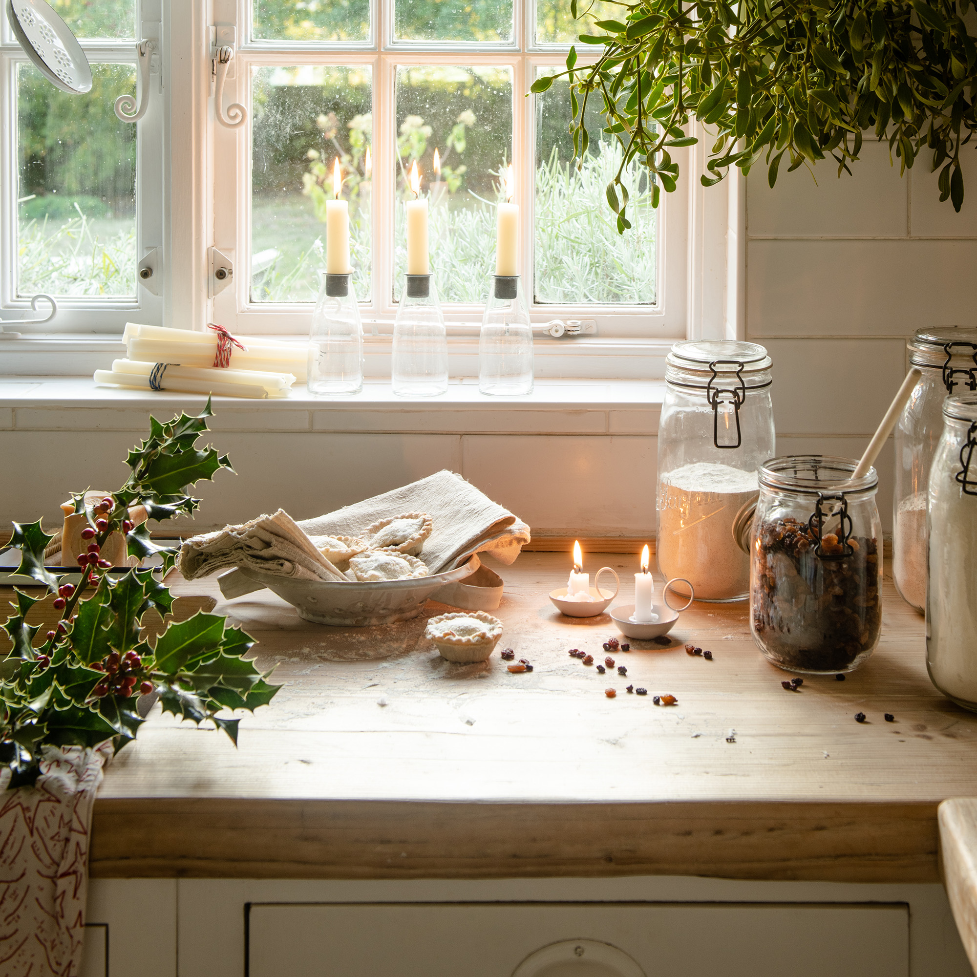 neutral kitchen with cream cabinets and wooden worktops dressed for christmas with mistletoe and festive foliage 1