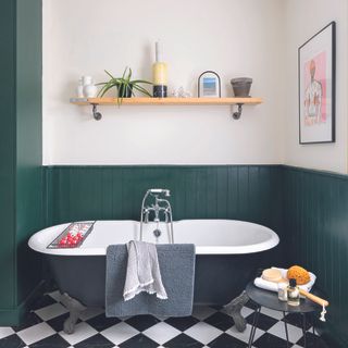 Bathroom with black bath, green panelling and open shelving