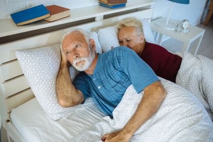 man in bed with his wife worried