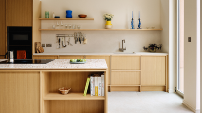 bright kitchen with beams on the ceiling and light wooden, expressed cabinetry