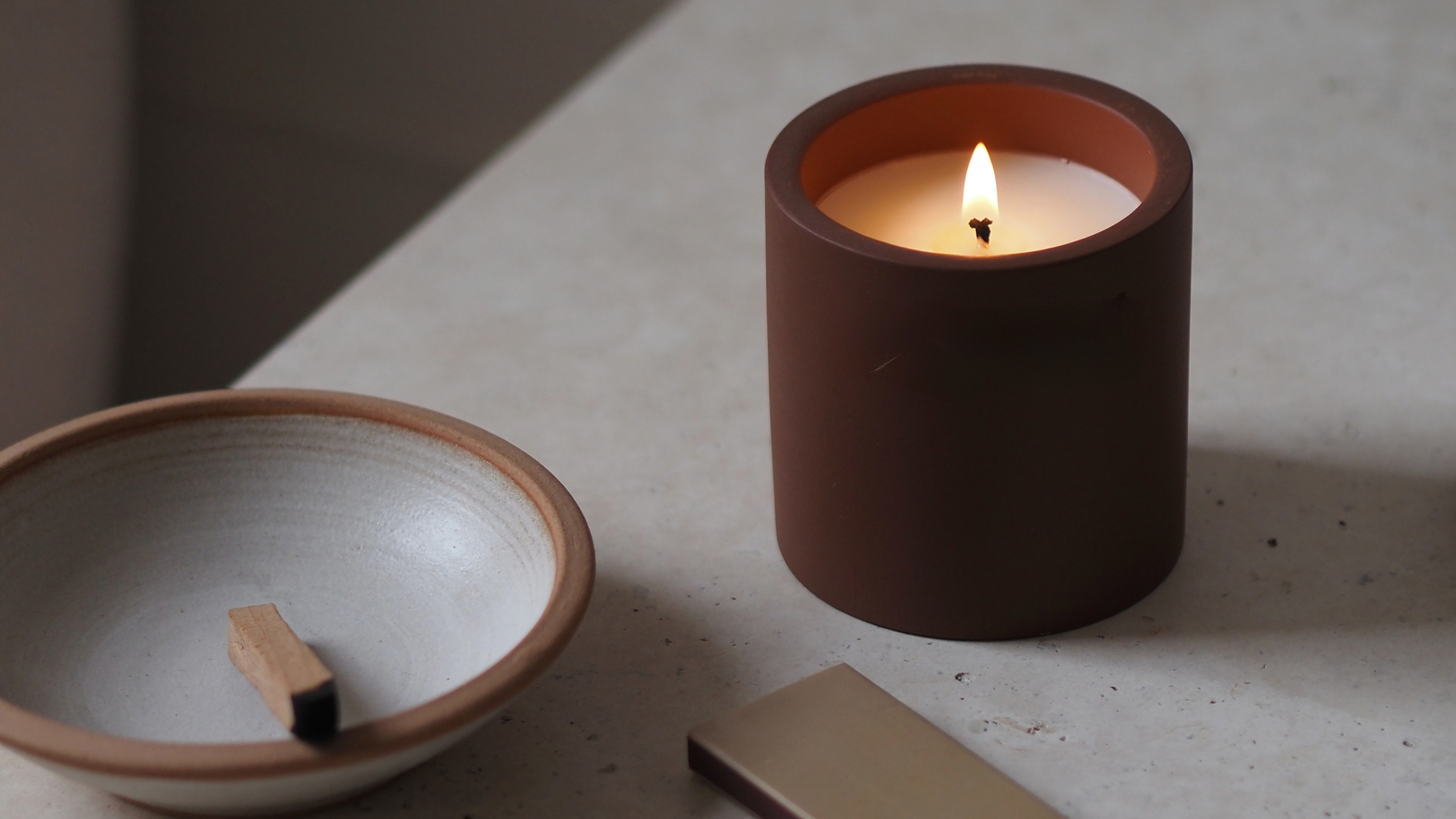 a lit candle on a stone top