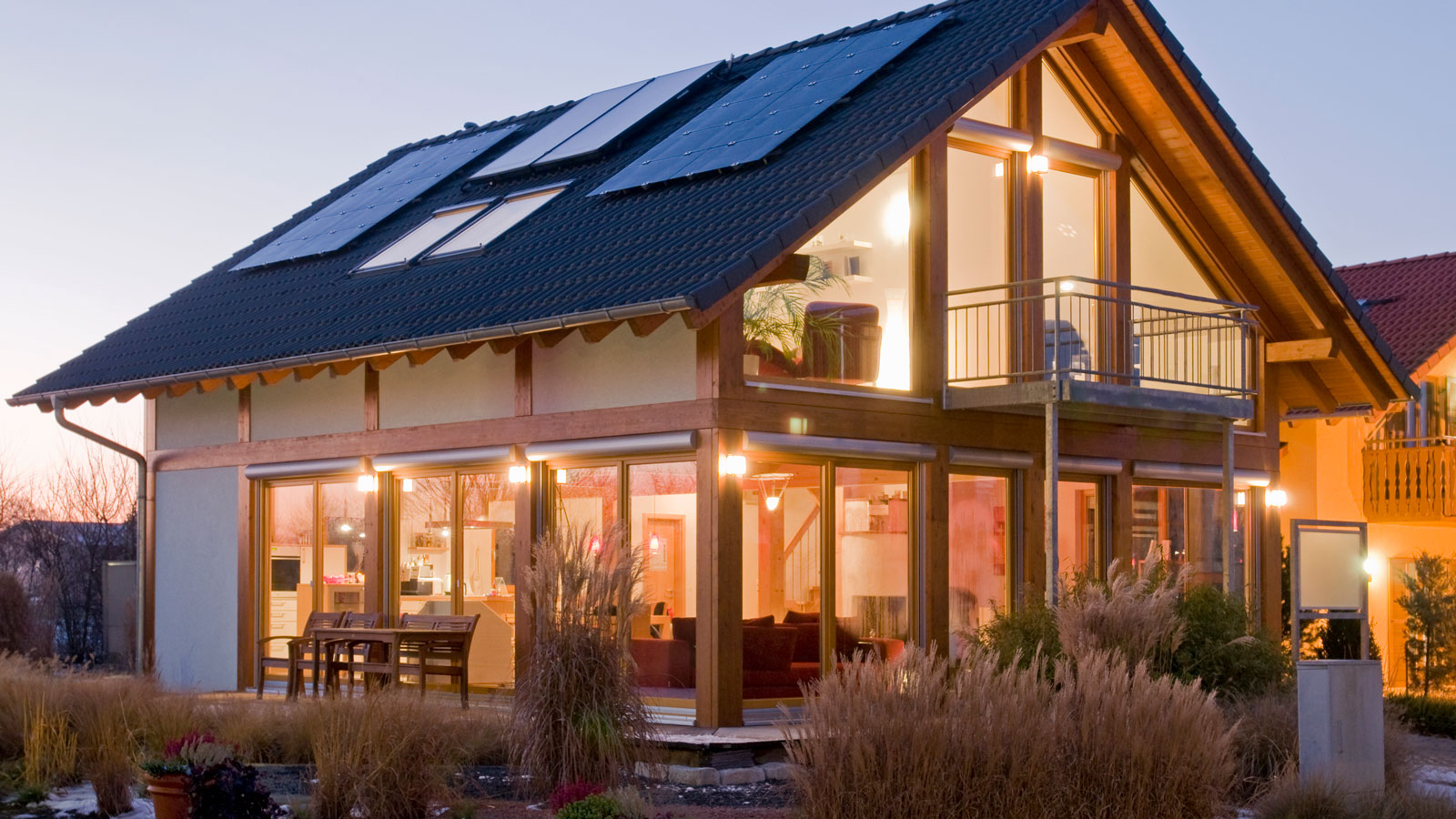 modern oak framed house with lots of glass and solar panels on the roof