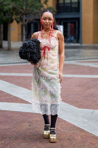 A guest in lace dress at Simone Rocha SS24 GettyImages-1687189606