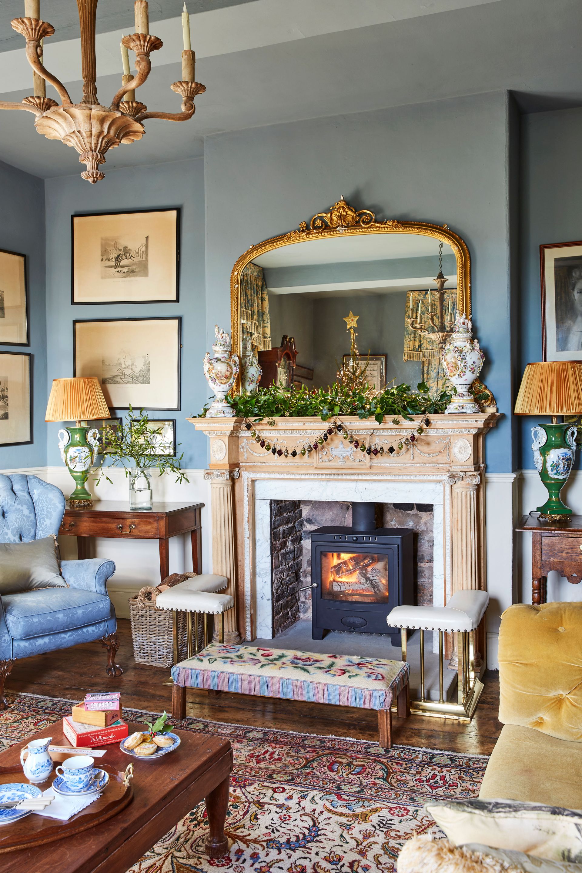 blue living room with open fireplace and overmantel mirrror