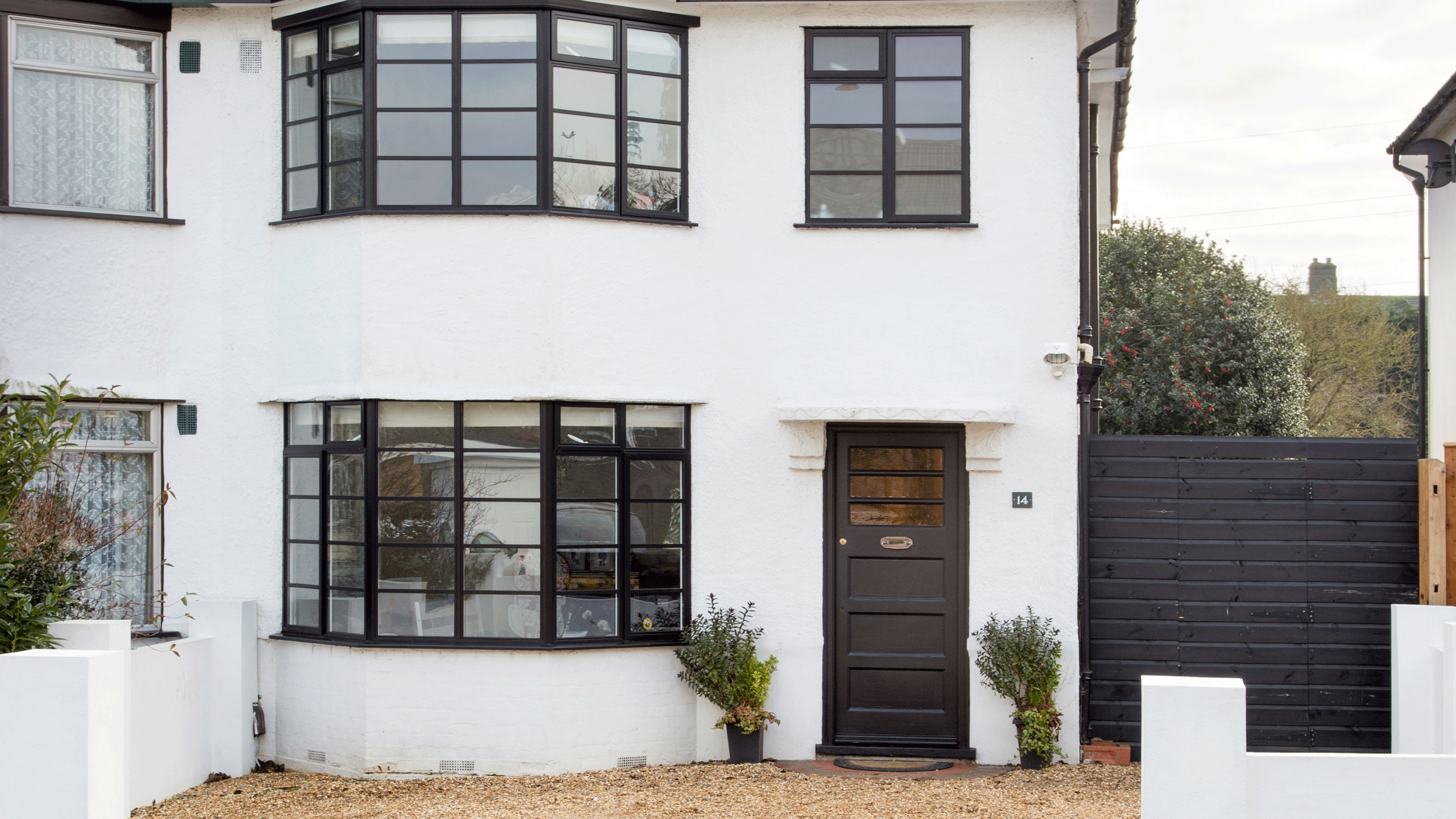 Blue-grey house with two chimneys, wooden door and charcoal roof