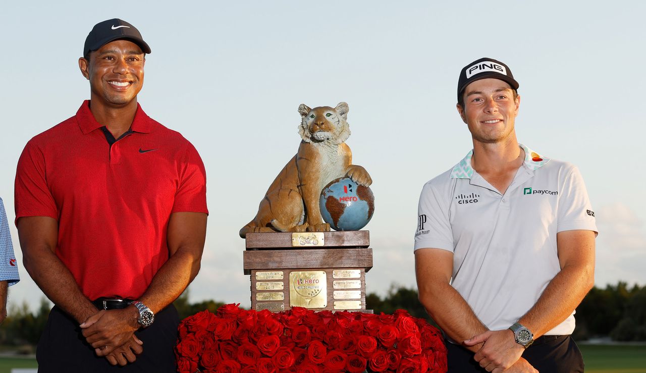 Tiger Woods and Viktor Hovland stand next to the Hero World Challenge trophy