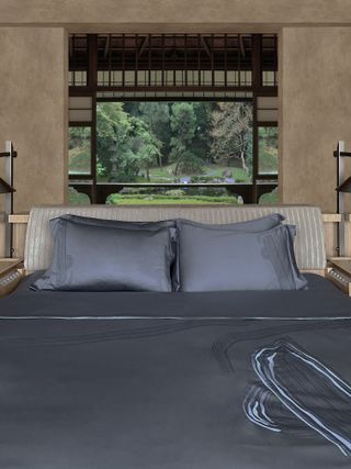 A bed in front of a window facing a traditional Japanese garden