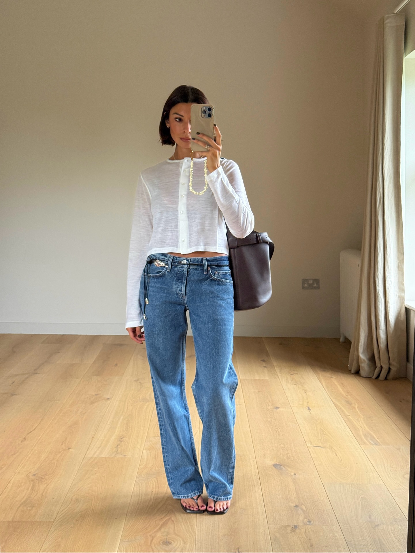 An image of @smythsisters wearing a button-down top, one of the best long-sleeved tops for women.