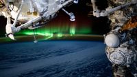 earth can be seen from space as a ribbon of green light appears to float over the atmosphere