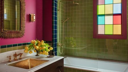 a green and pink bathroom with a stained glass window