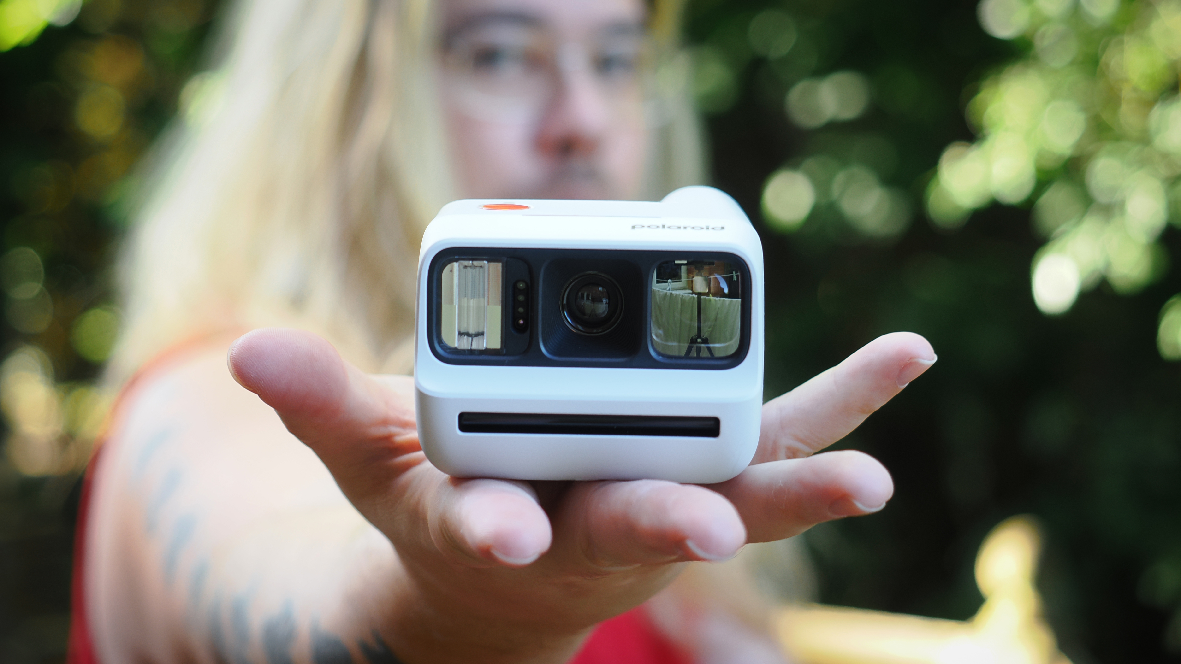 James Artaius holding a Polaroid Go Gen 3 in the palm of his hand, outdoors