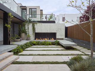 large outdoor fire place set into a concrete hearth in an urban garden