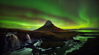 The Northern Lights shine over Kirkjufell mountain, Iceland