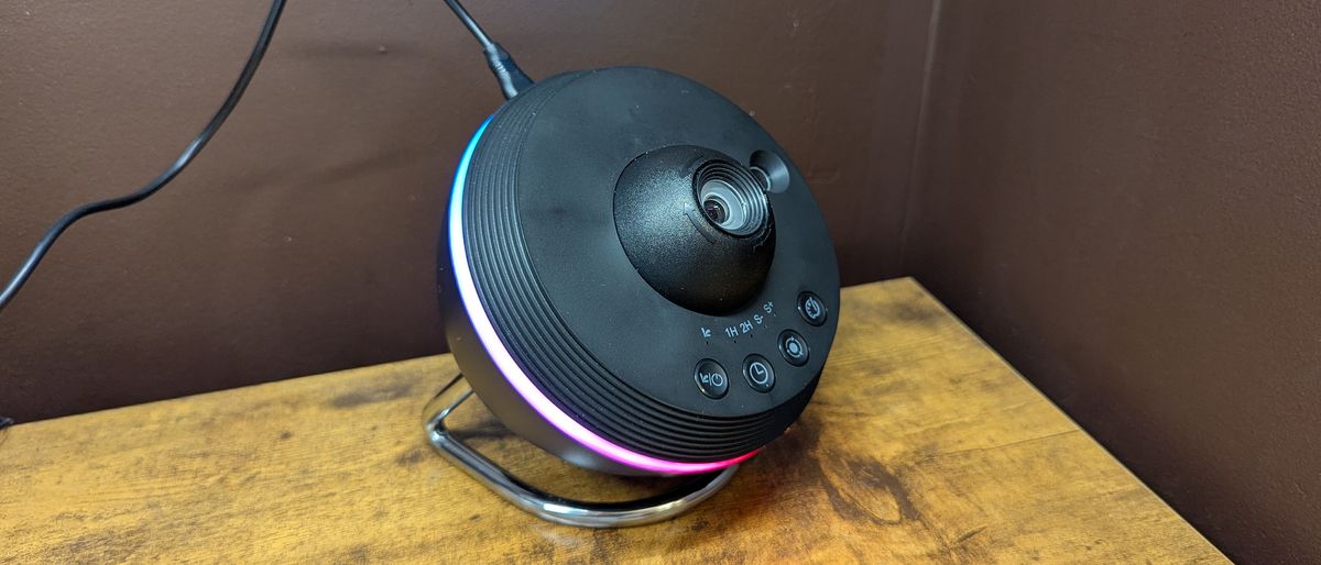 The Ainael Meteor and Galaxy Projector on a wooden table against a brown wall