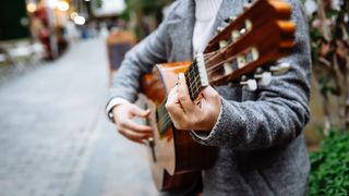 Unidentified Street Musician: Woman Playing Guitar on City Streets