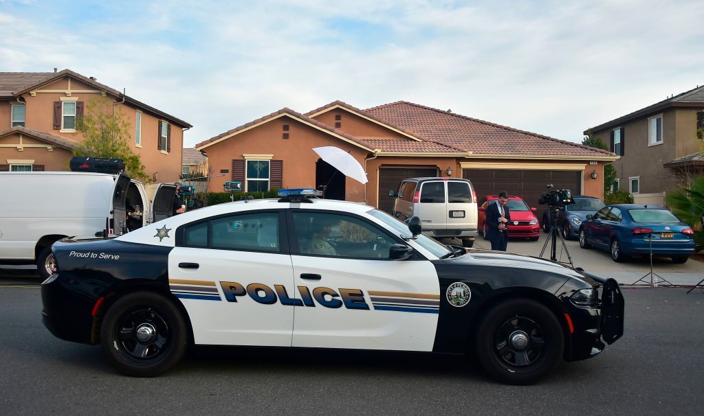 A police car parks in front of 160 Muir Woods Road from where authorities rescued 13 malnourished children held captive by their parents in Perris, California