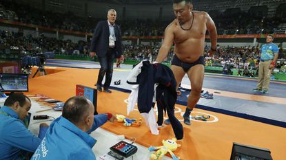 Mongolia's Mandakhnaran Ganzorig's coach reacts after the judges announced that Uzbekistan's Ikhtiyor Navruzov won following a video replay in their men's 65kg freestyle bronze medal match on