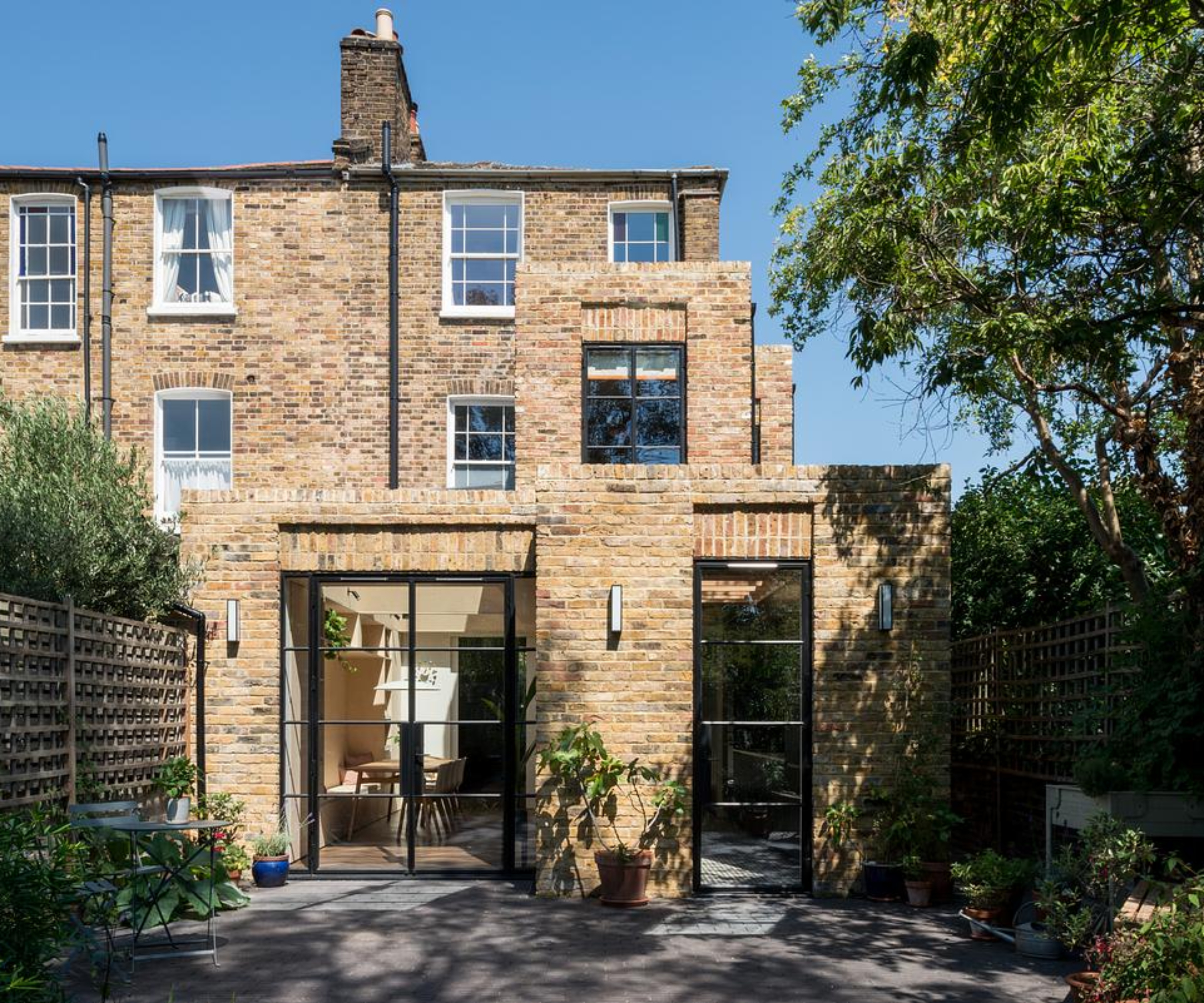 rear flat roof brick extension to brick house with three different roof heights and crittal style glazing