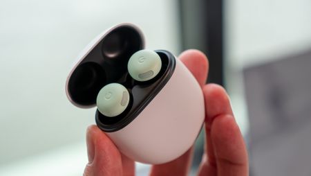 Holding the green Google Pixel Buds Pro 2 in their case