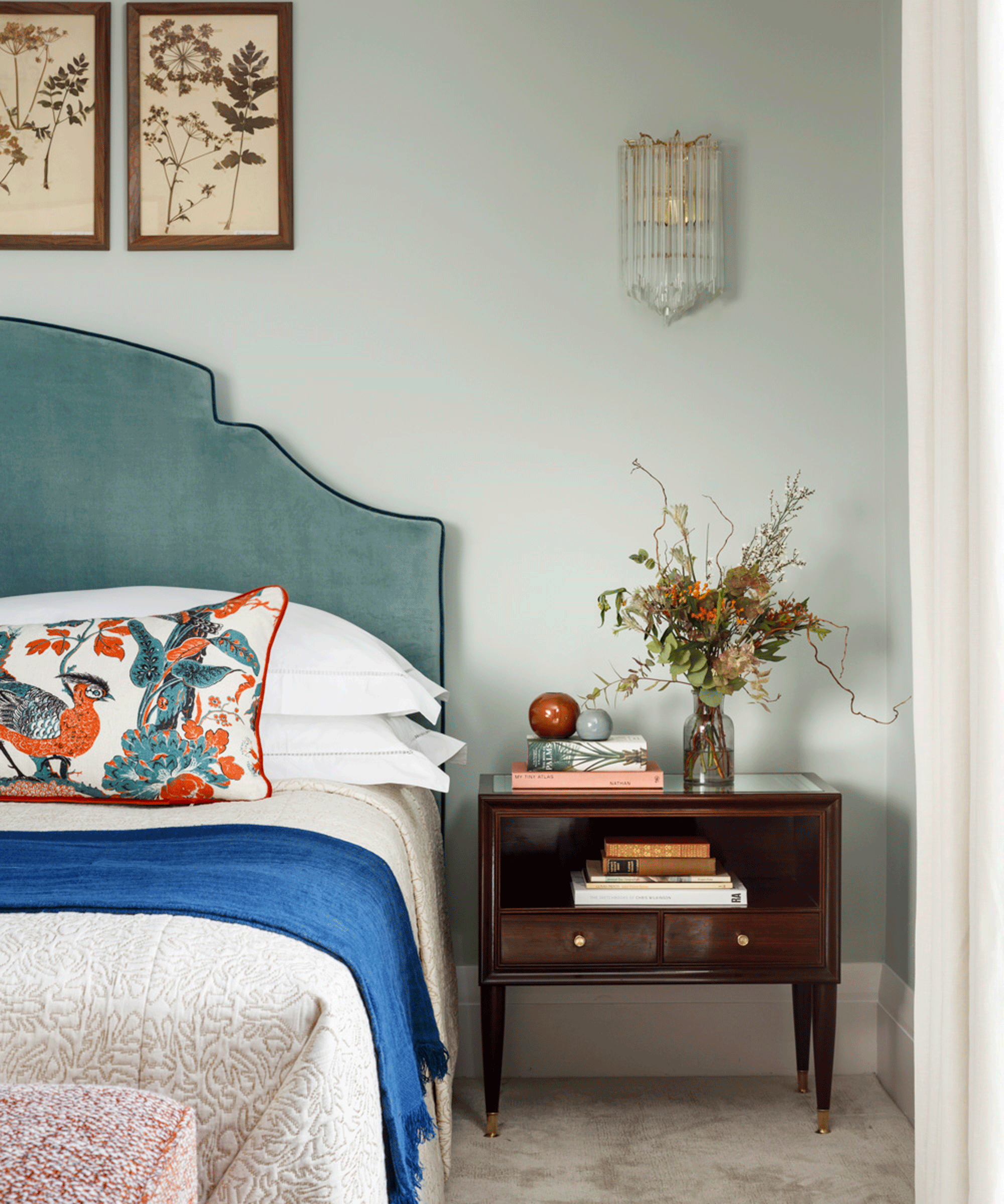 Bedroom with teal headboard and orange pattern cushion