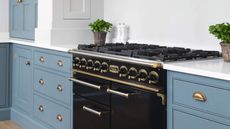 A black range cooker in a blue and white kitchen