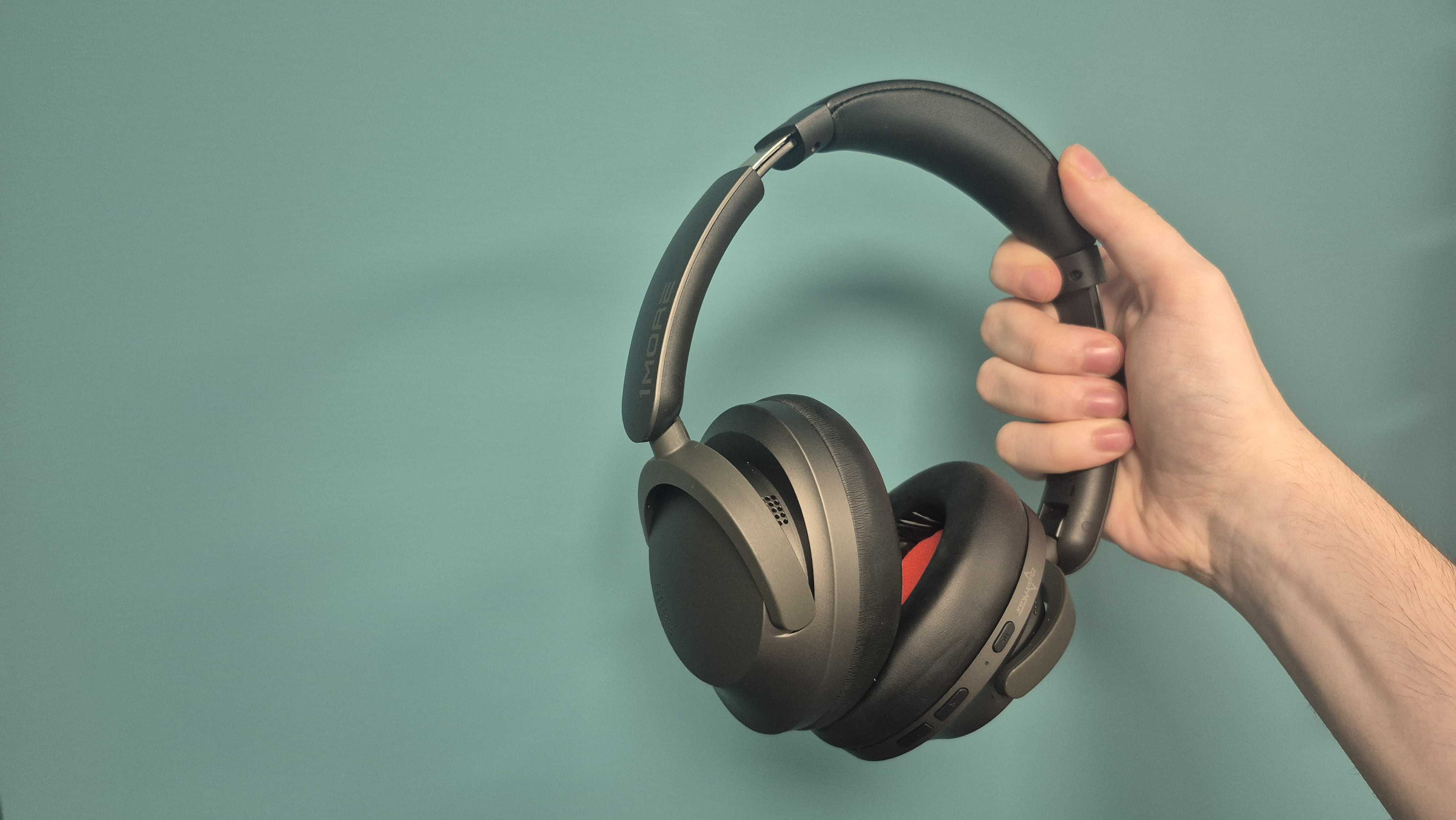 1More Sonoflow Pro HQ51 headphones held in a hand, on teal background at Future Labs