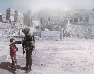 Un soldat parlant à un jeune garçon devant des ruines