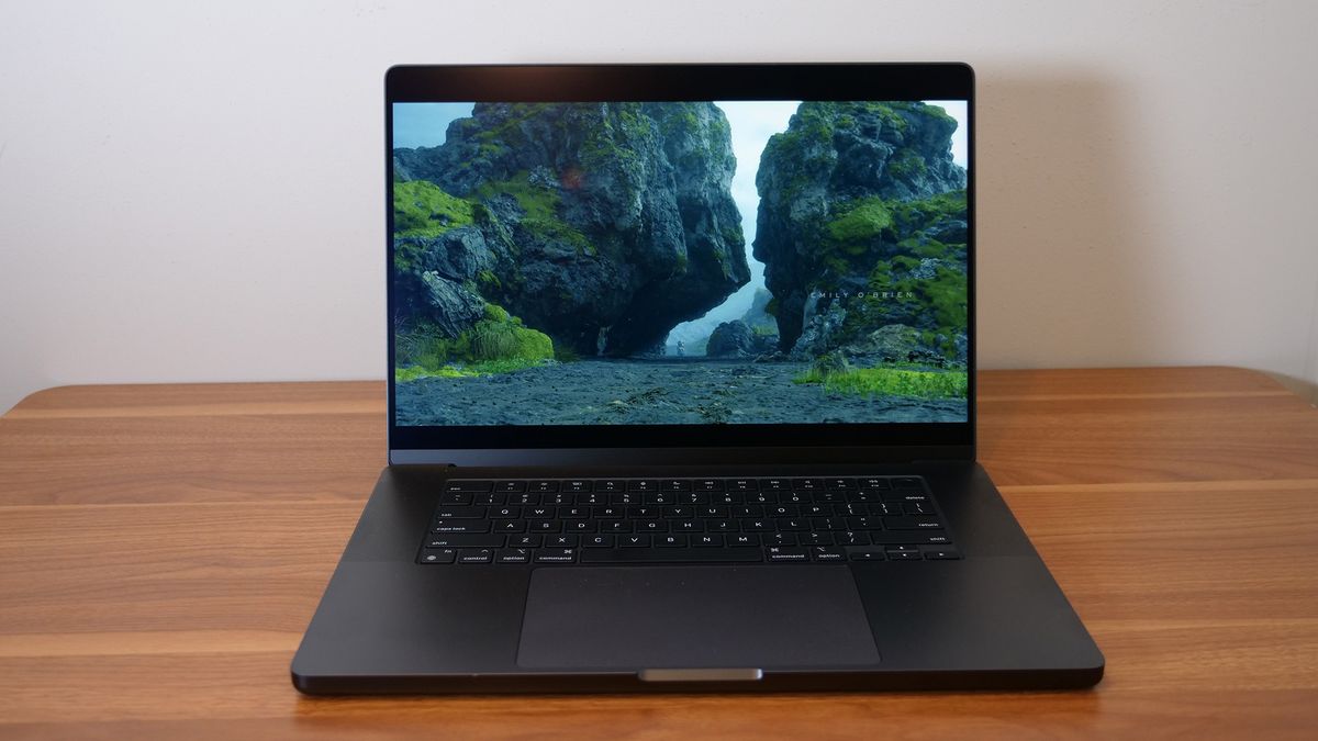 Apple MacBook Pro 16-inch M4 Pro 2024 open on a wooden desk playing Death Stranding