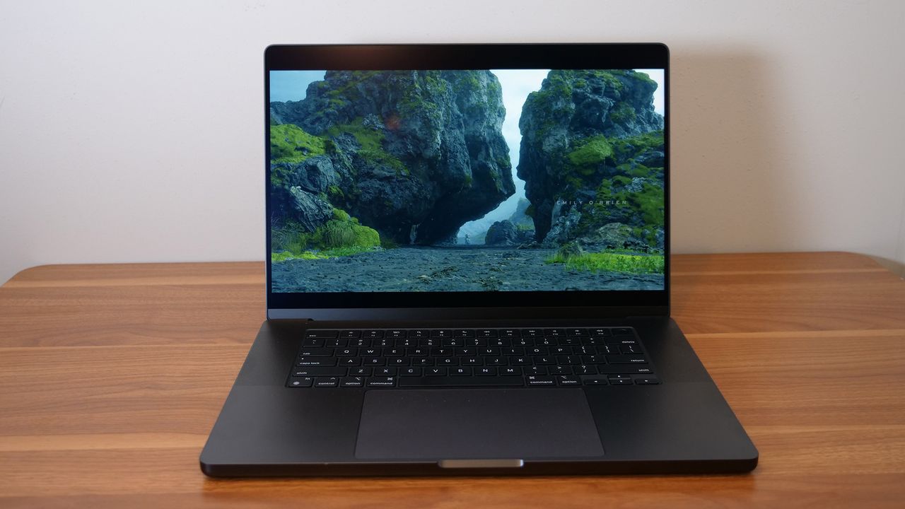 Apple MacBook Pro 16-inch M4 Pro 2024 open on a wooden desk playing Death Stranding