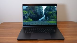 Apple MacBook Pro 16-inch M4 Pro 2024 open on a wooden desk playing Death Stranding