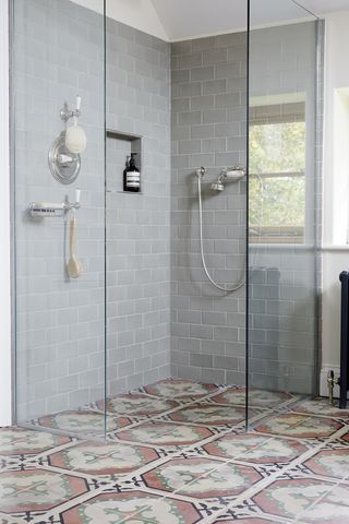 Pastel encaustic tiles on the floor of a wet room style small bathroom