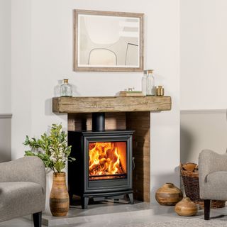 woodburning fire in a white living room with wooden lintel beam
