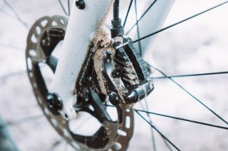 A close up of a muddy brake caliper