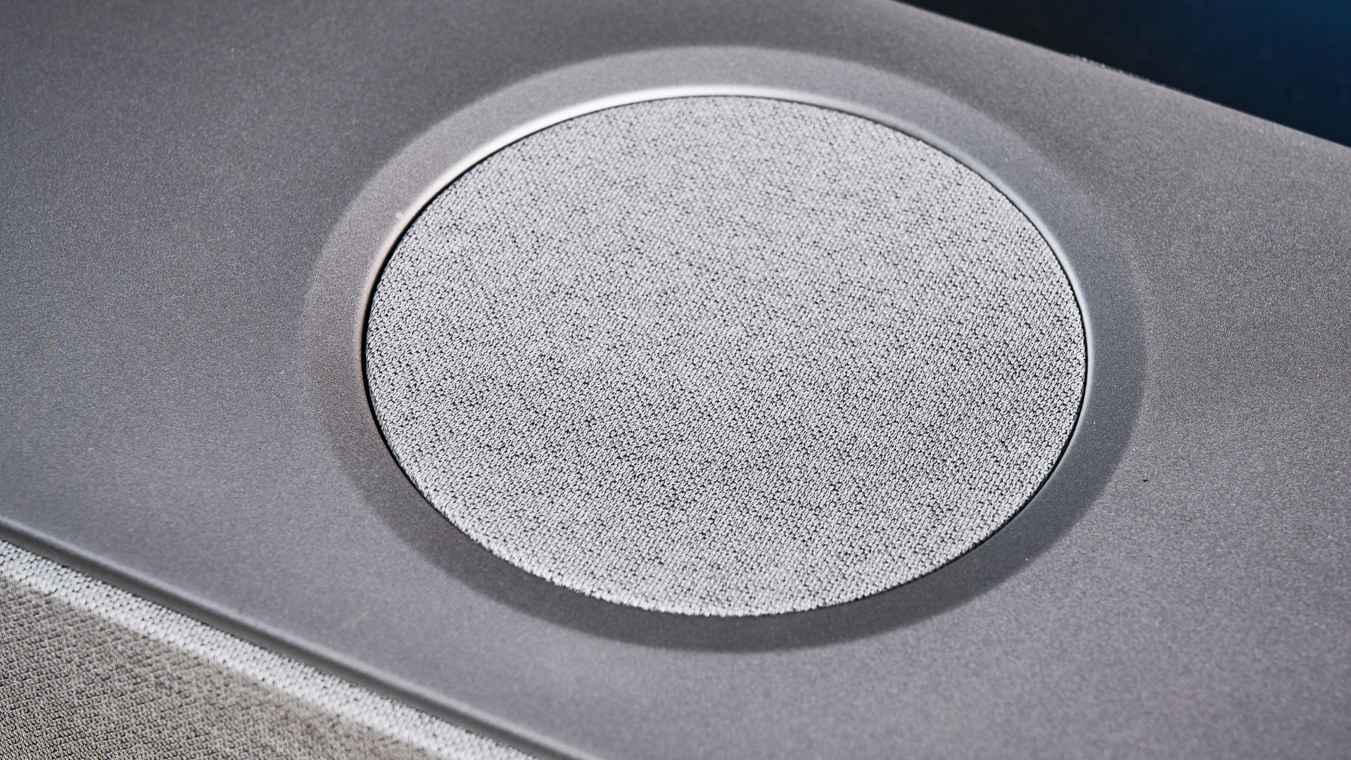 the KEF XIO soundbar in gray photographed with a TV and the Tom's Guide blue background