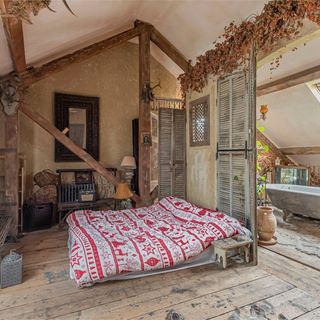 bedroom with wooden flooring and bed with wooden beam