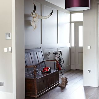 hallway with white wall and wooden floor and bench and bicycle