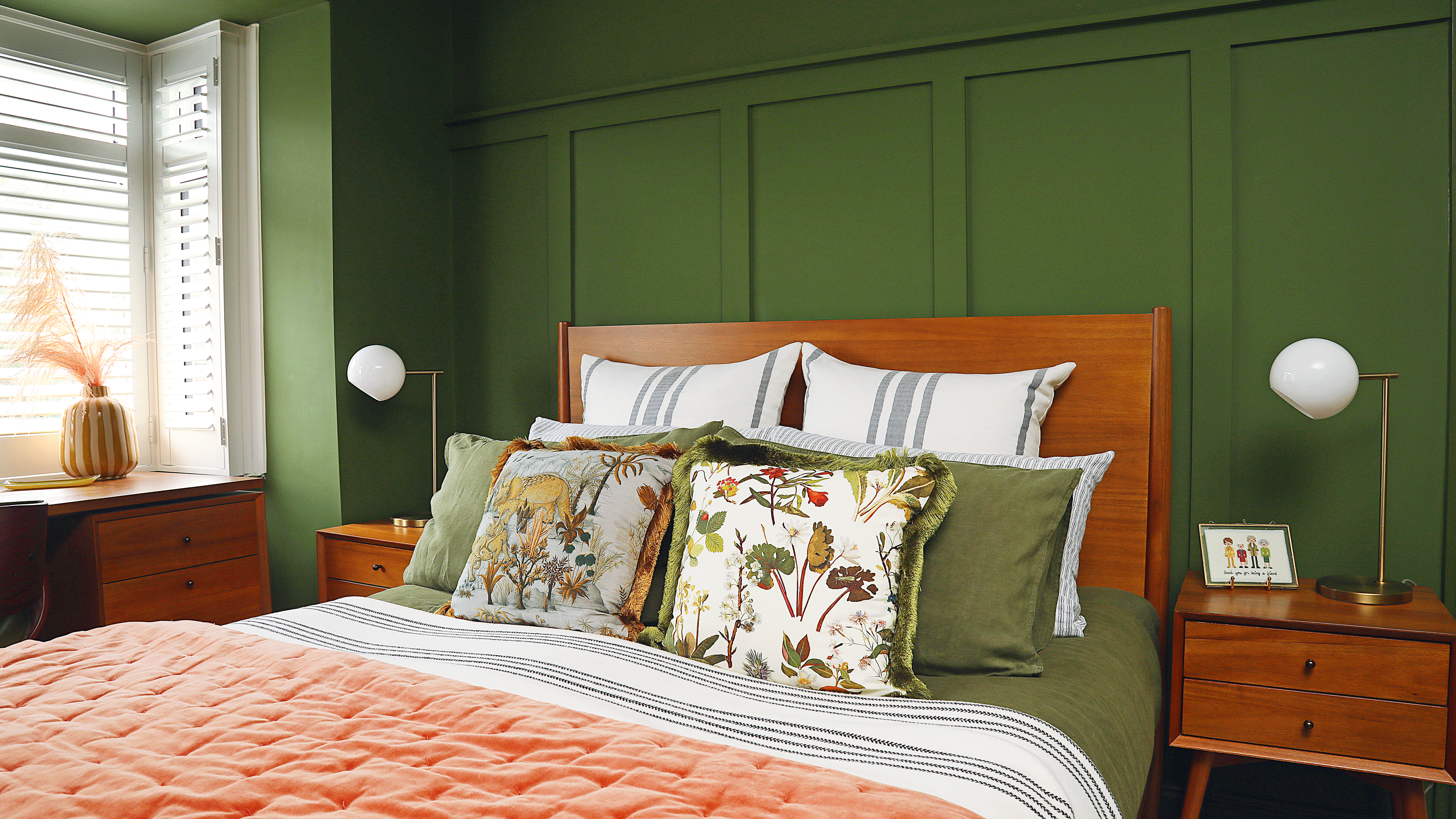 Green bedroom with wooden bed and green cushions